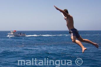 Un étudiant faisant un saut étoile depuis le bateau