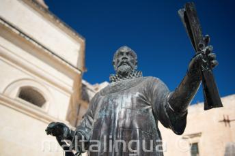 Une statue à Malte d'un homme tenant un parchemin