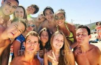 Étudiants de l'école de langue à la plage avec des drôles de tête