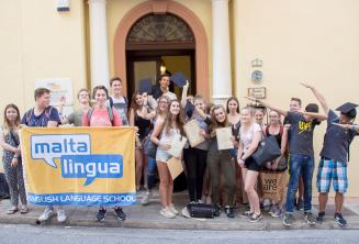 Groupe d'étudiants d'anglais ados à la porte principale de l'école